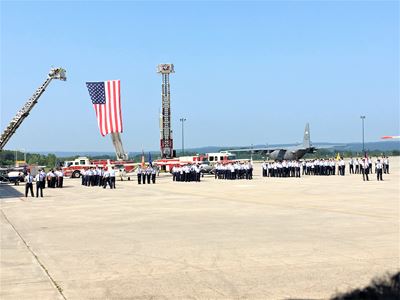 CAP cadets graduation day outside on air field standing under USA flag.