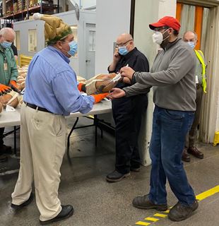 Employees receiving Turkeys by Raymond Corporation management team. 