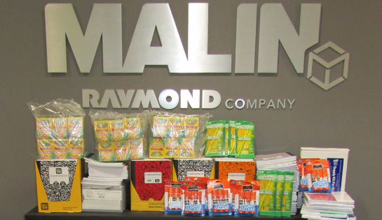 Photo of school supplies in front of the Malin logo
