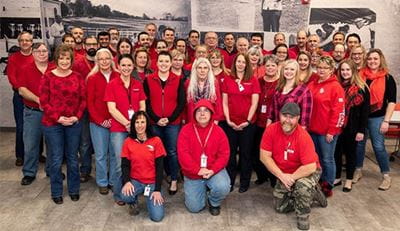 Photo of Raymond employees posing, all wearing red